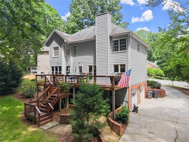 1172 Malvern Hunt Ct, Lawrenceville, GA 30043 - rear view of property featuring concrete driveway, a deck, a garage, a chimney, and stairs