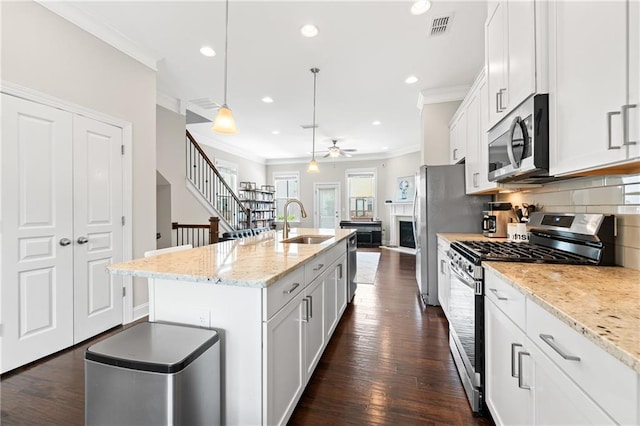 4458 Dunblane Ave, Sugar Hill, GA 30518 - kitchen featuring appliances with stainless steel finishes, crown molding, a ceiling fan, white cabinets, and a kitchen island with sink