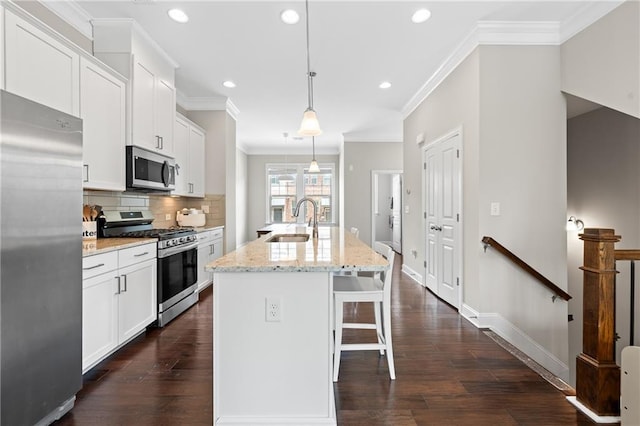 4458 Dunblane Ave, Sugar Hill, GA 30518 - kitchen featuring appliances with stainless steel finishes, a kitchen bar, tasteful backsplash, recessed lighting, and ornamental molding