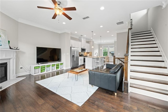 4458 Dunblane Ave, Sugar Hill, GA 30518 - living area featuring a ceiling fan, ornamental molding, recessed lighting, dark wood-type flooring, and a glass covered fireplace