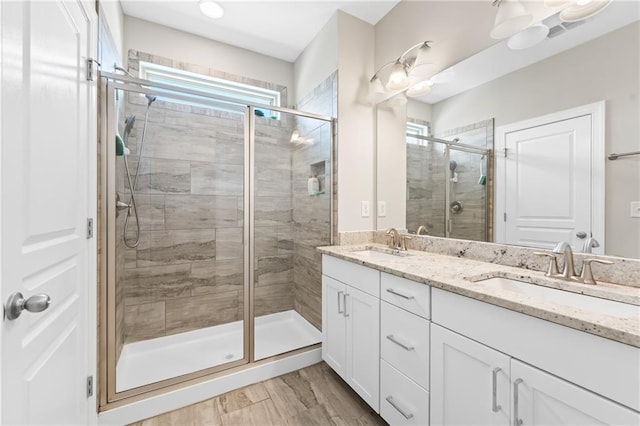 4458 Dunblane Ave, Sugar Hill, GA 30518 - full bathroom with double vanity, a shower stall, and wood finished floors