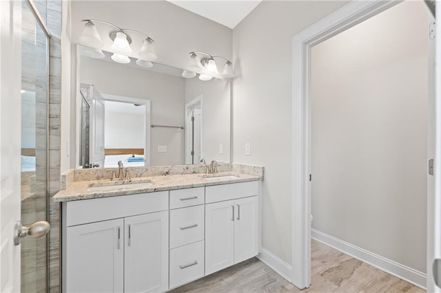 4458 Dunblane Ave, Sugar Hill, GA 30518 - bathroom with double vanity, wood finished floors, and a shower with door
