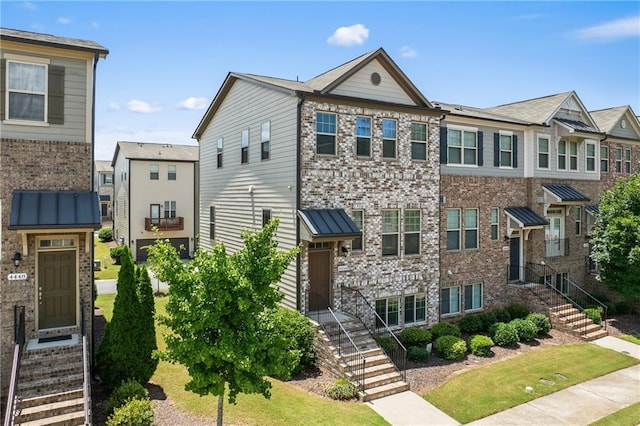 4458 Dunblane Ave, Sugar Hill, GA 30518 - view of property featuring brick siding, a standing seam roof, and a metal roof