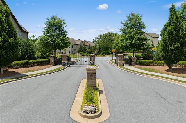 4458 Dunblane Ave, Sugar Hill, GA 30518 - view of asphalt road featuring sidewalks, a gate, curbs, and a gated entry