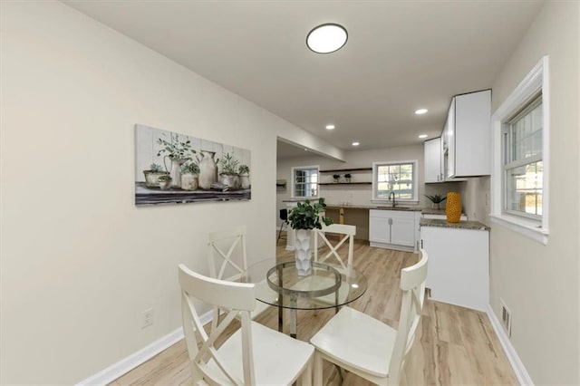 dining space with light hardwood / wood-style floors and sink