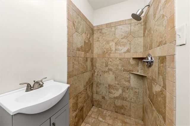 bathroom with a tile shower and vanity