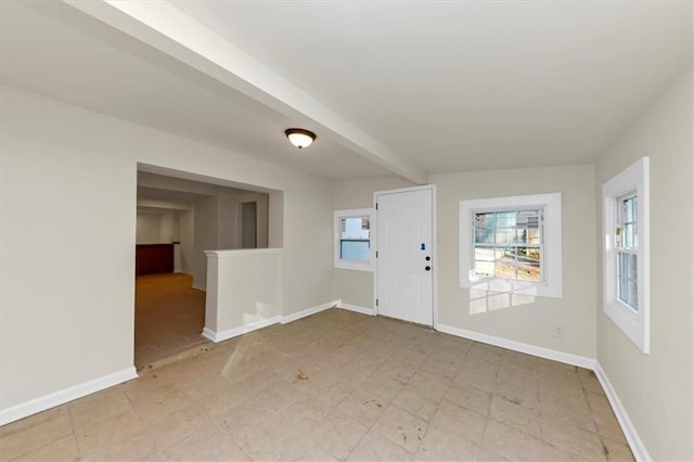 foyer entrance featuring beamed ceiling