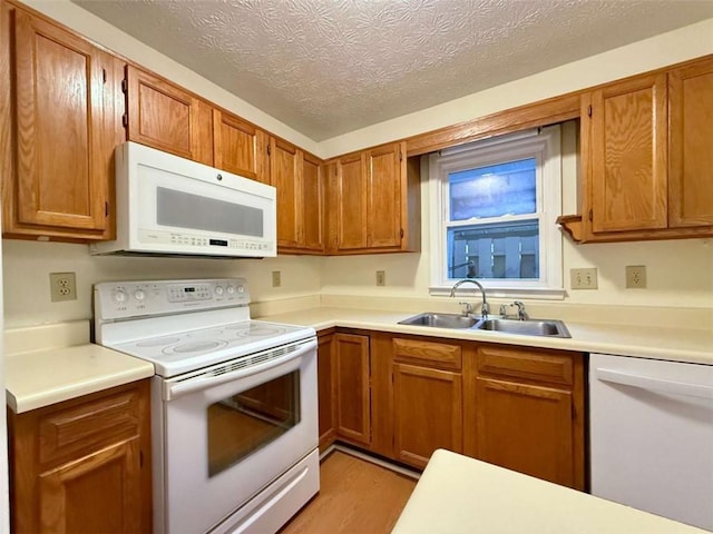 3533 Mulberry Way, Duluth, GA 30096 - kitchen featuring white appliances, light wood-type flooring, brown cabinets, a textured ceiling, and light countertops