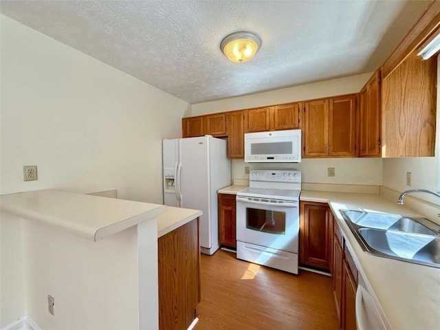 3533 Mulberry Way, Duluth, GA 30096 - kitchen with white appliances, wood finished floors, brown cabinetry, a peninsula, and light countertops