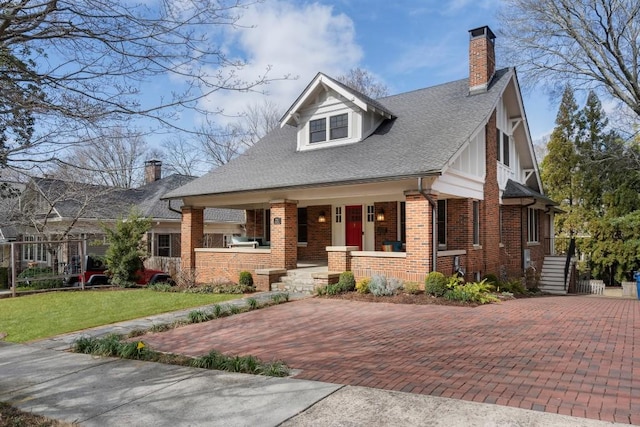 view of front of home with covered porch and a front lawn