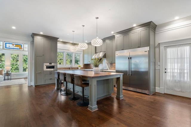 kitchen featuring appliances with stainless steel finishes, pendant lighting, gray cabinetry, and a breakfast bar