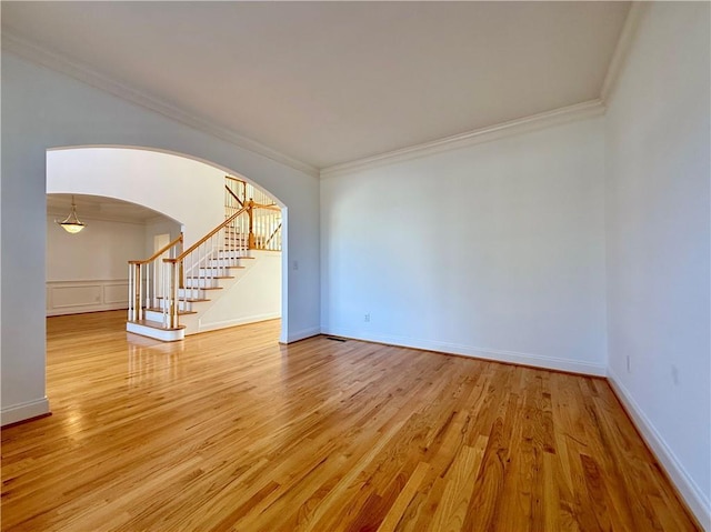 6765 Crofton Dr, Alpharetta, GA 30005 - spare room featuring ornamental molding, stairs, arched walkways, and light wood finished floors