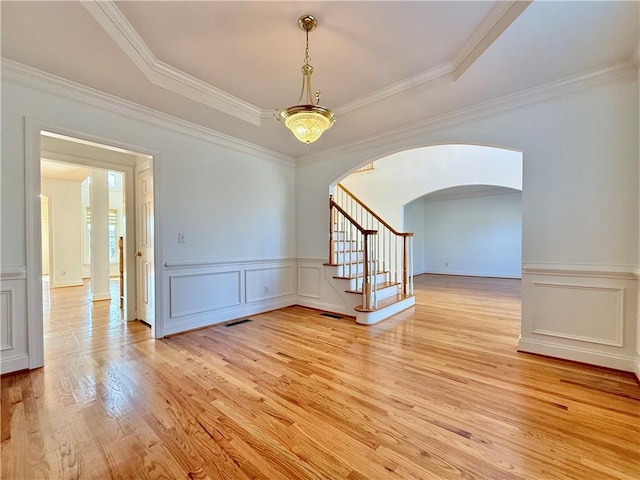 6765 Crofton Dr, Alpharetta, GA 30005 - spare room featuring a decorative wall, light wood-style flooring, arched walkways, stairway, and wainscoting