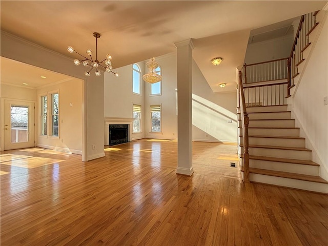 6765 Crofton Dr, Alpharetta, GA 30005 - unfurnished living room with wood finished floors, stairs, a chandelier, ornamental molding, and baseboards