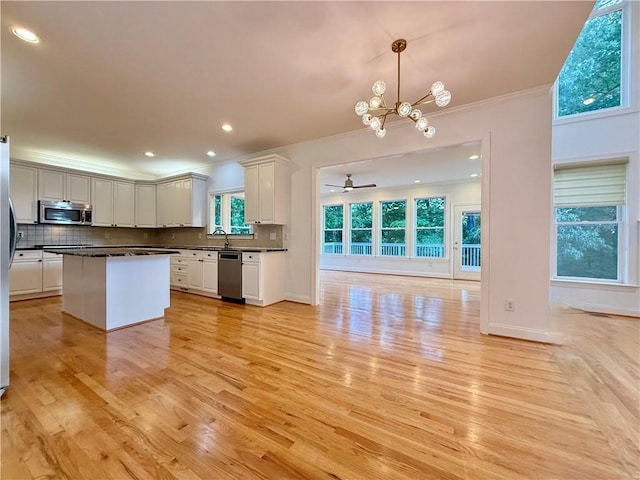 6765 Crofton Dr, Alpharetta, GA 30005 - kitchen with appliances with stainless steel finishes, dark countertops, crown molding, backsplash, and white cabinetry