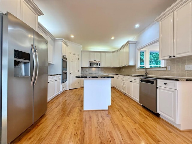 6765 Crofton Dr, Alpharetta, GA 30005 - kitchen with stainless steel appliances, dark countertops, a center island, white cabinetry, and backsplash