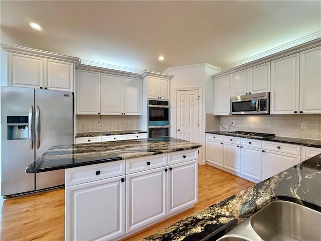 6765 Crofton Dr, Alpharetta, GA 30005 - kitchen featuring appliances with stainless steel finishes, a center island, light wood-style floors, tasteful backsplash, and recessed lighting