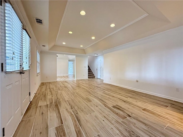 6765 Crofton Dr, Alpharetta, GA 30005 - spare room featuring a tray ceiling, crown molding, light wood-style flooring, stairs, and baseboards