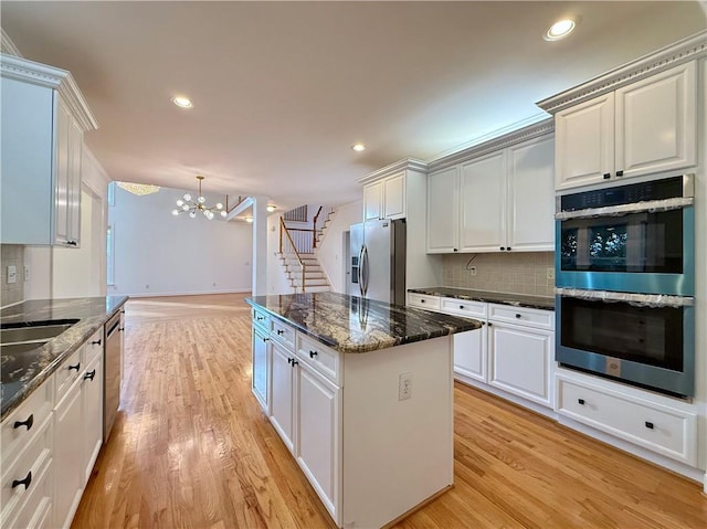 6765 Crofton Dr, Alpharetta, GA 30005 - kitchen with stainless steel appliances, a chandelier, light wood-style floors, tasteful backsplash, and a kitchen island