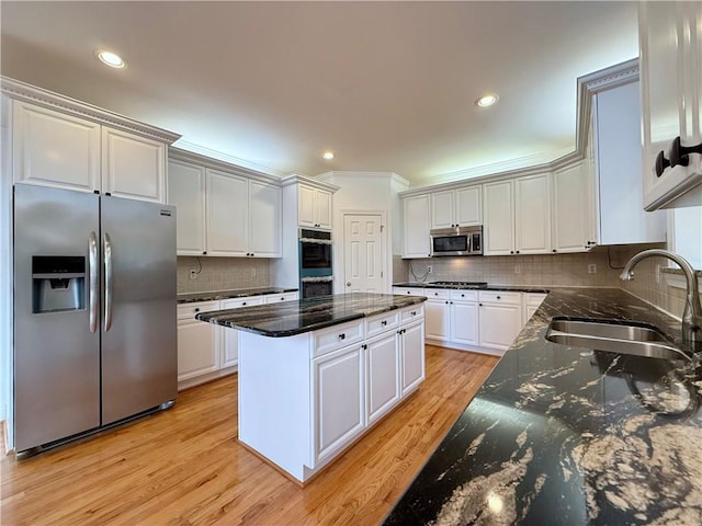 6765 Crofton Dr, Alpharetta, GA 30005 - kitchen with stainless steel appliances, a sink, a kitchen island, decorative backsplash, and light wood finished floors