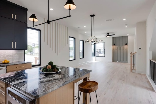 3960 Clairmont Rd Unit 2, Chamblee, GA 30341 - kitchen featuring healthy amount of natural light, light wood-style floors, recessed lighting, light stone countertops, and a breakfast bar area
