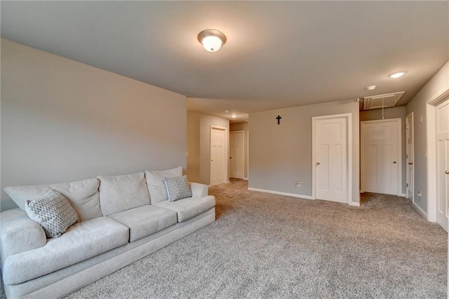 living room featuring attic access, light carpet, and baseboards