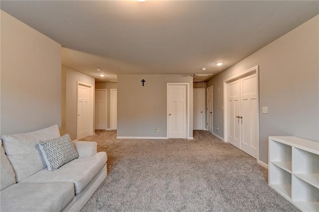 unfurnished living room with attic access, light colored carpet, baseboards, and recessed lighting