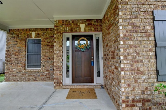 entrance to property featuring brick siding and a porch