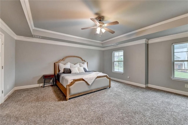 carpeted bedroom featuring a raised ceiling, baseboards, ornamental molding, and ceiling fan