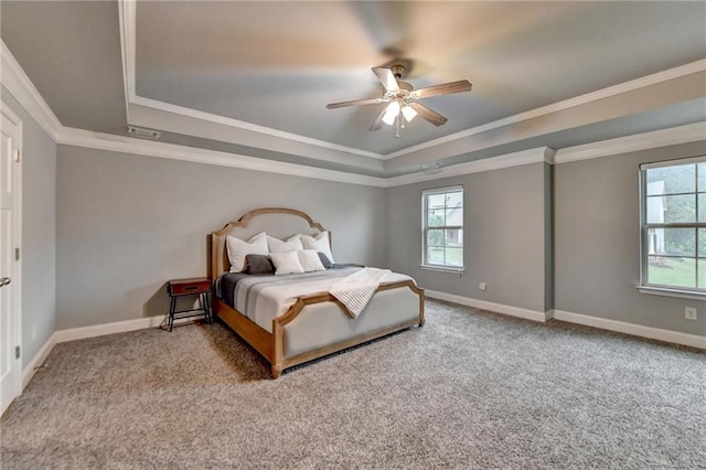 carpeted bedroom with a raised ceiling, ornamental molding, baseboards, and ceiling fan