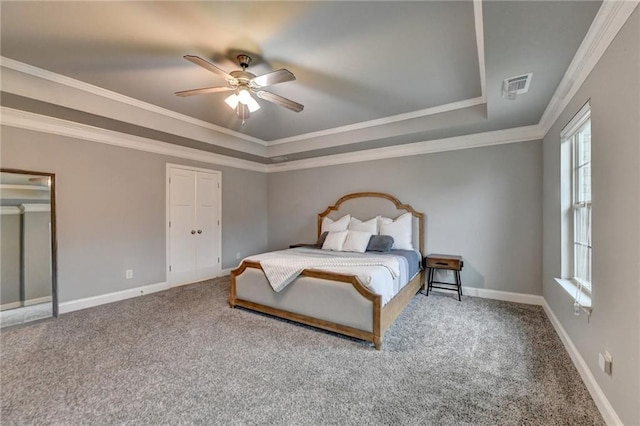 carpeted bedroom featuring a tray ceiling, baseboards, ornamental molding, and a ceiling fan