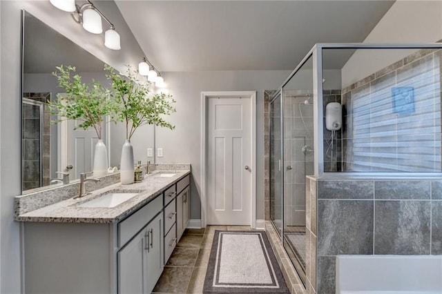 full bathroom with a stall shower, double vanity, baseboards, and tile patterned flooring