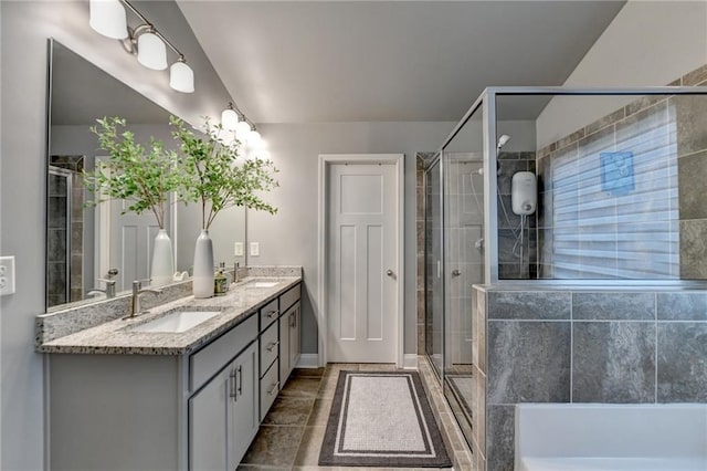 bathroom featuring a shower stall, double vanity, tile patterned floors, and baseboards