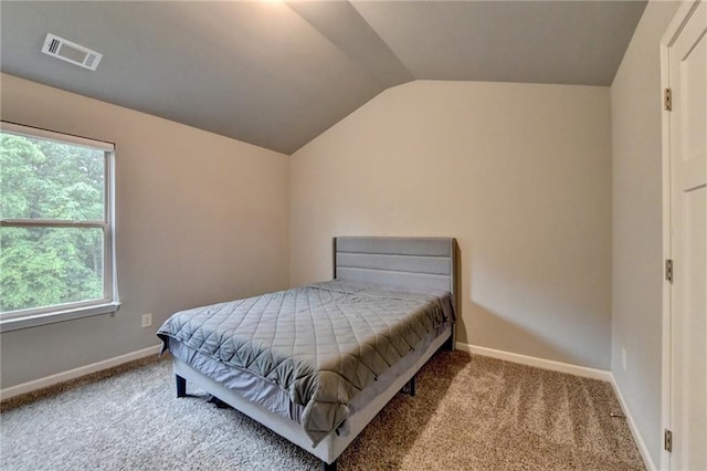 carpeted bedroom featuring lofted ceiling, multiple windows, and baseboards