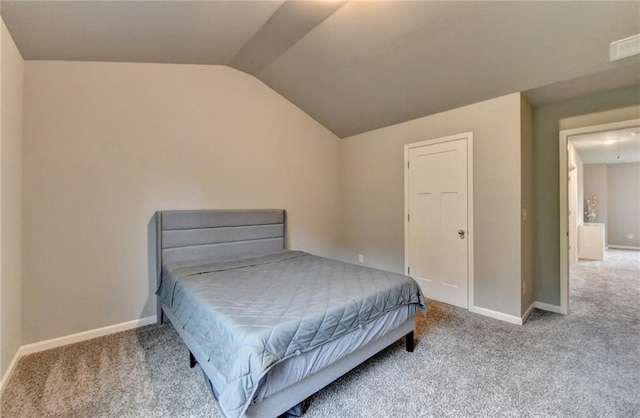 carpeted bedroom featuring vaulted ceiling and baseboards