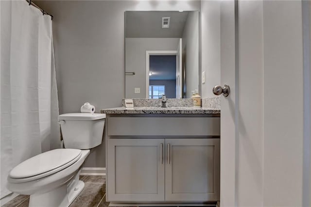 bathroom with vanity, toilet, and baseboards