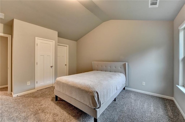 carpeted bedroom featuring lofted ceiling and baseboards