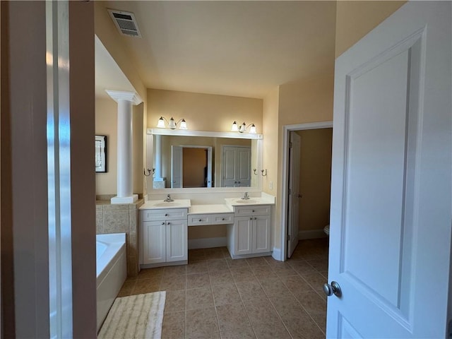 full bathroom featuring tile patterned flooring, visible vents, decorative columns, and a garden tub