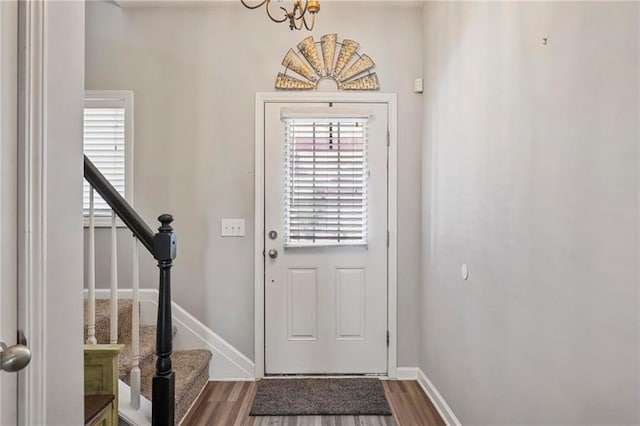 entrance foyer with stairway, wood finished floors, and baseboards