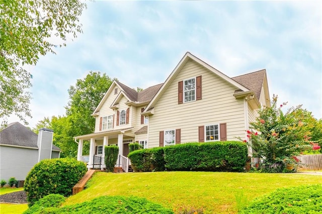 traditional-style home featuring a front lawn and a porch
