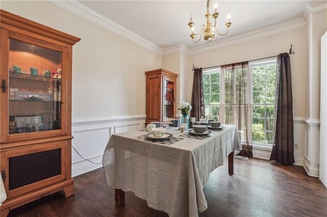 dining area featuring a chandelier, crown molding, dark wood finished floors, and wainscoting