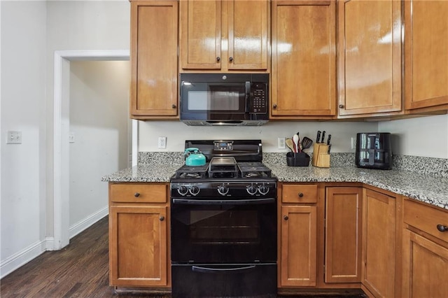 kitchen with black appliances, dark wood finished floors, baseboards, and light stone countertops