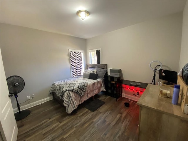 bedroom with dark wood-type flooring and baseboards