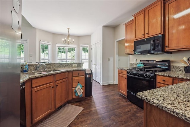 kitchen with black appliances, a sink, dark wood-style floors, a chandelier, and brown cabinets