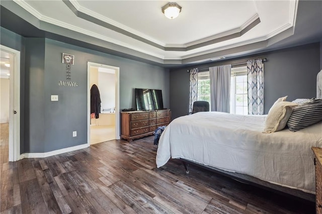 bedroom featuring a raised ceiling, crown molding, dark wood finished floors, ensuite bathroom, and baseboards