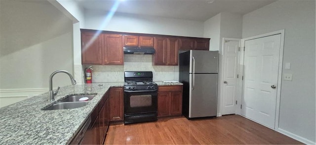 2061 Fosco Dr, Duluth, GA 30097 - kitchen featuring gas stove, freestanding refrigerator, a sink, under cabinet range hood, and light stone counters