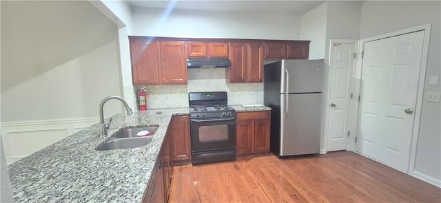 2061 Fosco Dr, Duluth, GA 30097 - kitchen with freestanding refrigerator, gas stove, a sink, under cabinet range hood, and light stone countertops