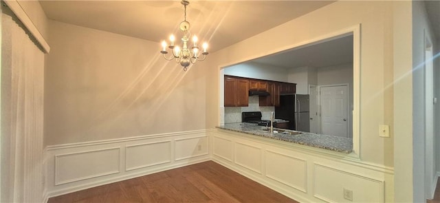 2061 Fosco Dr, Duluth, GA 30097 - unfurnished dining area with a chandelier, dark wood-style flooring, a wainscoted wall, a decorative wall, and a sink
