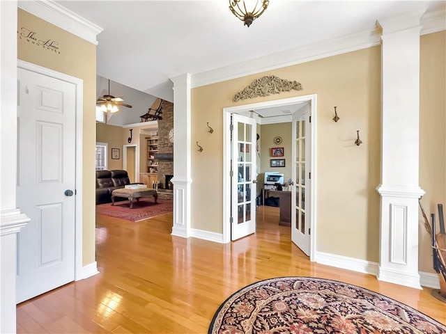 corridor featuring ornate columns, light wood-style flooring, and french doors