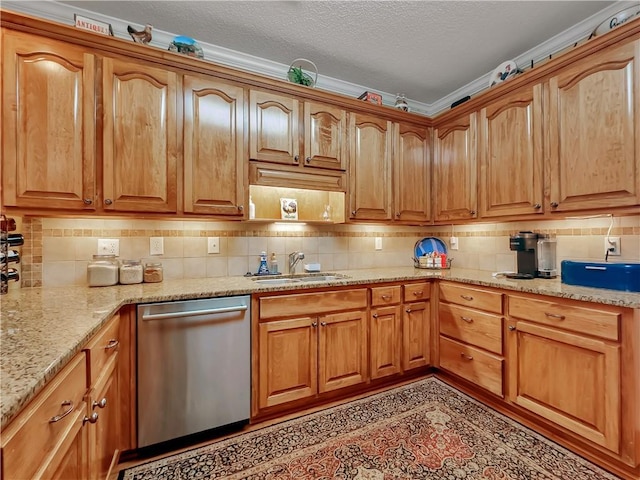 kitchen featuring stainless steel dishwasher, backsplash, a sink, and light stone countertops